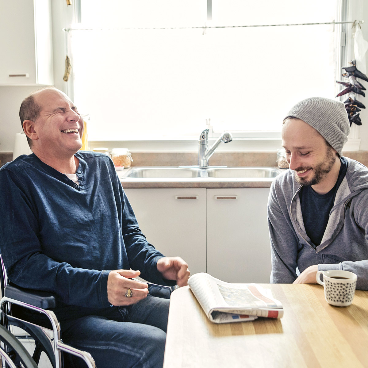 Man visiting a temporary disabled friend and having a coffee.