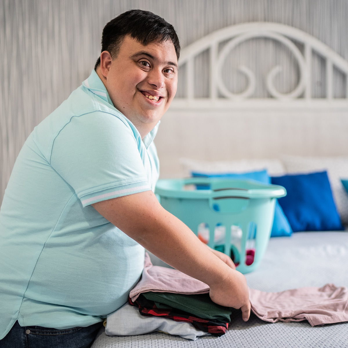 Portrait of special needs mid adult man folding clothes