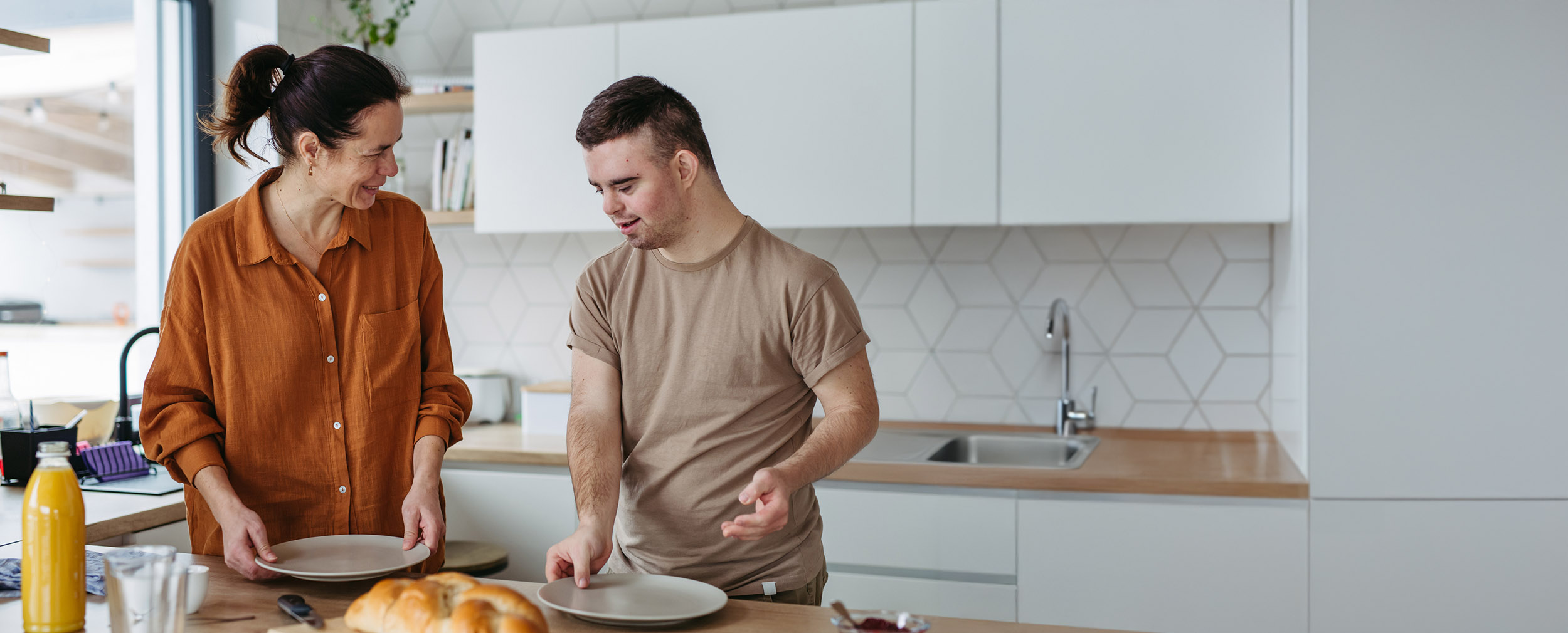 Young man prepares breakfast with his support worker